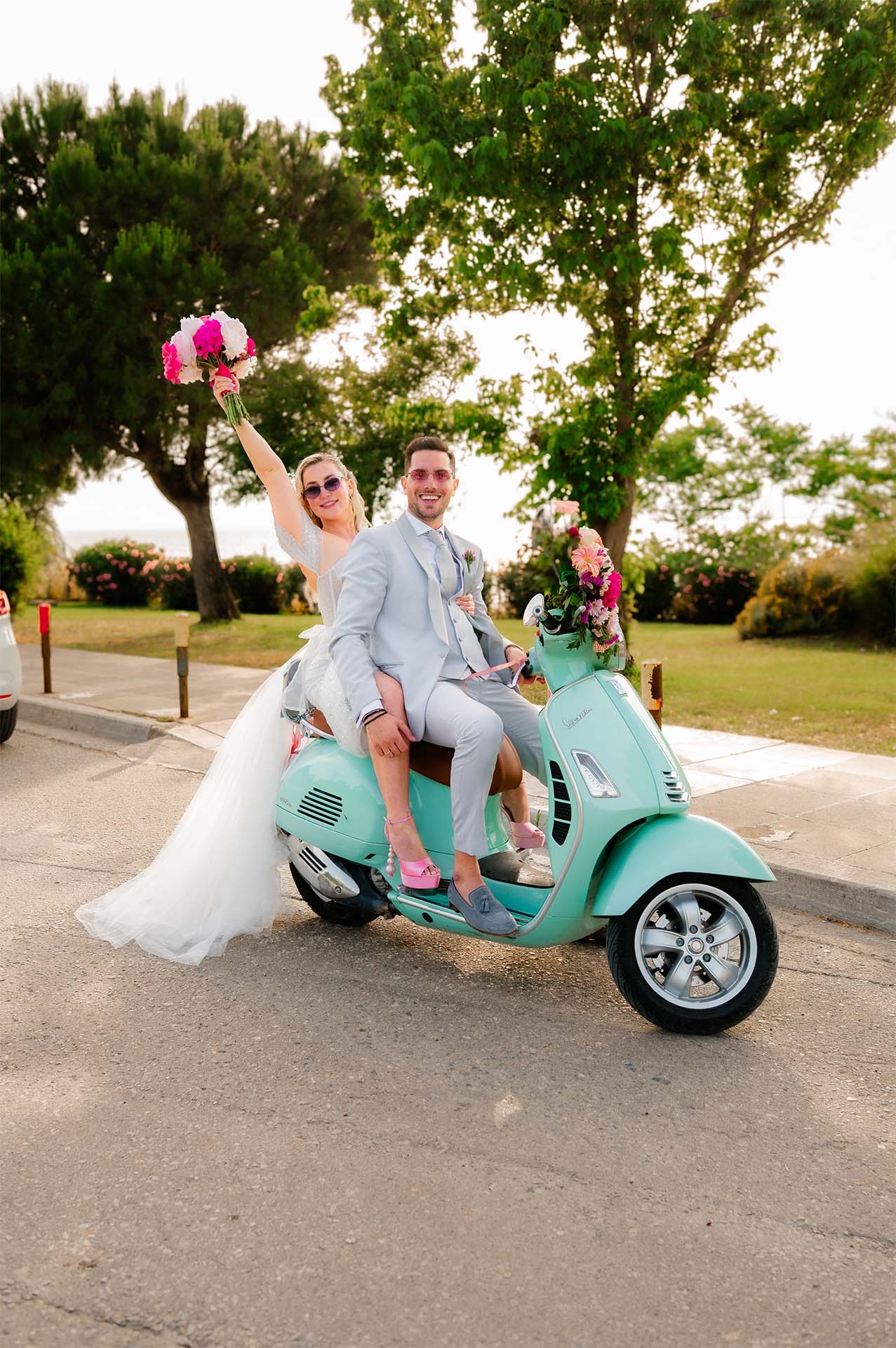 Bride and groom are photographed in front of their vintage Vespa.